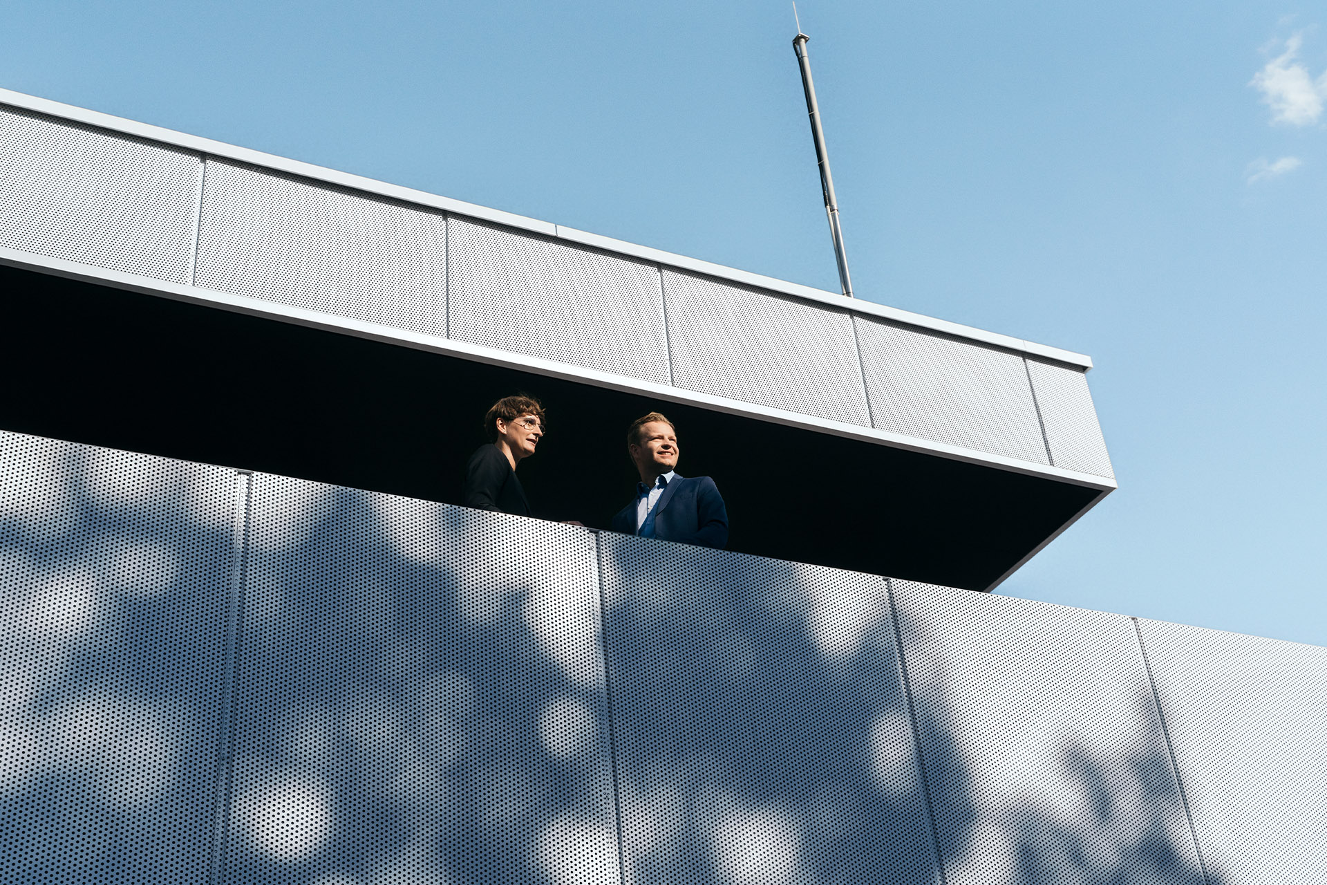 Expertos en sustentabilidad, la Dra. Johanna Klewitz y Malte Vömel, en el balcón de la sala de estar del hub de carga de Audi.